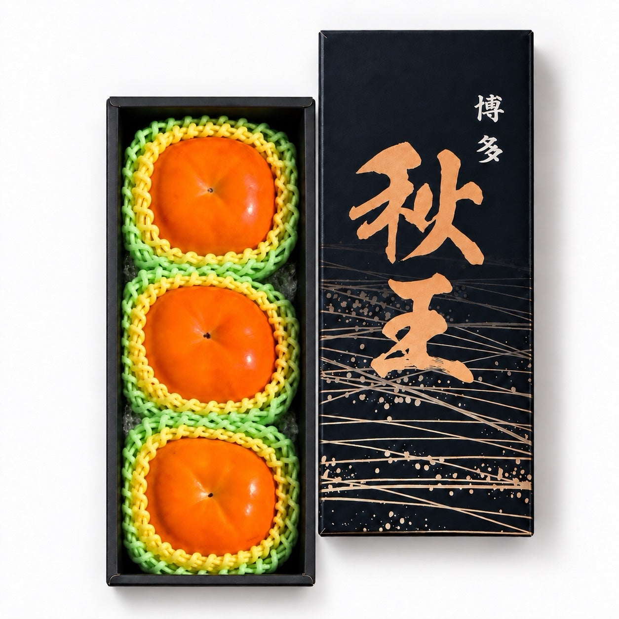 Three Akiou Japanese persimmons in a black gift box with protective fruit sleeves and a matching lid